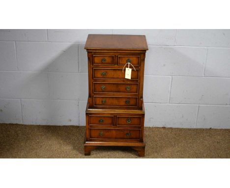 A Georgian-style reproduction miniature yew wood veneered chest-on-chest, rectangular, the upper section with two short and t