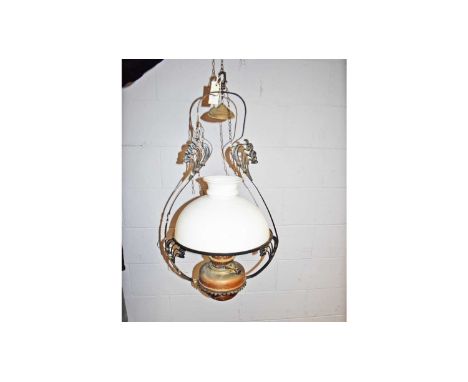 An Arts &amp; Crafts wrought metal and brass hanging oil lamp with opaque glass shade, 82cms high.