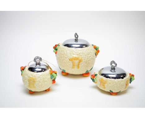 A graduated set of three Clarice Cliff 'Celtic Harvest' jars, with white metal covers, the tallest 16cms high.
