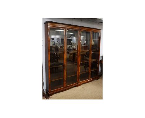 A large Edwardian-style mahogany and satinwood banded display case, the cavetto cornice above two pairs of tall glazed doors,