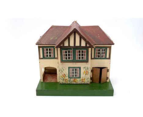 An early 20th Century Tri-ang doll's house, c.1930, of plywood construction, the front section opening on a hinge to reveal t