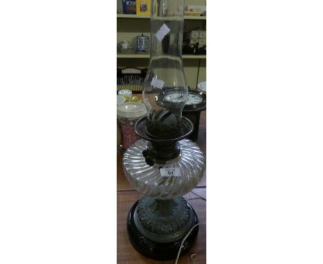 A Victorian oil lamp with clear glass font, floral decorated metal base 