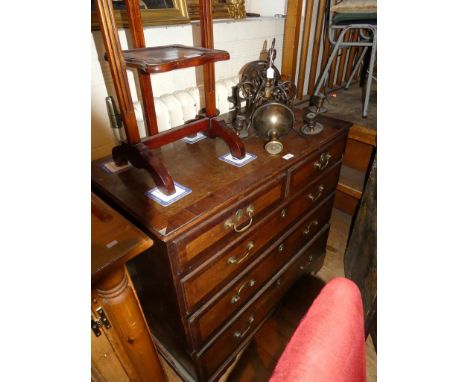 A George III oak and mahogany cross banded chest of two short and three long drawers raised on bracket feet 