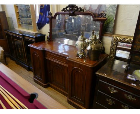 A Victorian mahogany breakfront sideboardThe arched mirrored back with pillar side supports and carved detail over a base wit