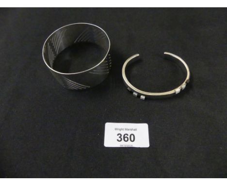 Two silver banglesTo include a torque and an openwork bangle, weight approx. 2.6oz. 