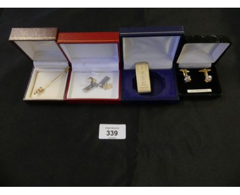 A selection of items to include a silver money clip, two pairs of cufflinks and a stick pin 