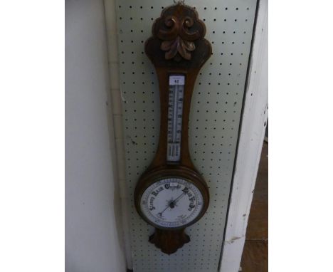 A late 19th Century barometer/thermometer combination, in carved oak case. 