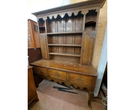 A 1.53m antique oak two part dresser with three shelf open plate rack and flanking narrow cupboards, over a base with three d