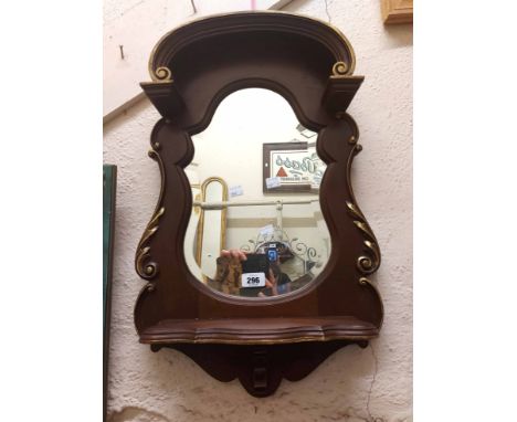 A 20th Century French mahogany ornate hall mirror with shaped bevelled plate, gilt acanthus scroll detail and shelf under