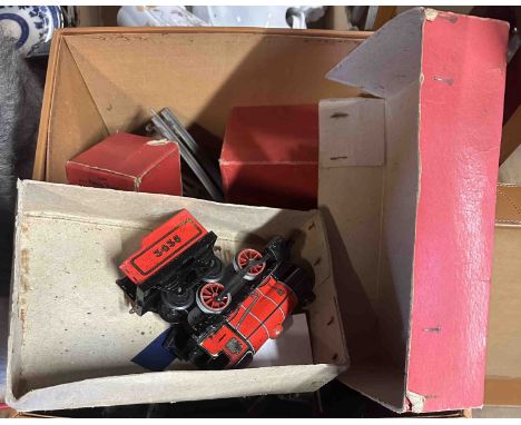 A faux leather storage box containing a quantity of 1930's Hornby '0' Gauge tinplate model railway items including engines, w