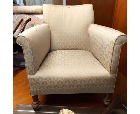 A 20th Century low tub elbow chair with repeat machine tapestry upholstery, set on chamfered front legs with casters