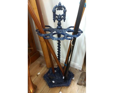 An antique later blue painted ornate cast iron stick stand with integral drip tray base