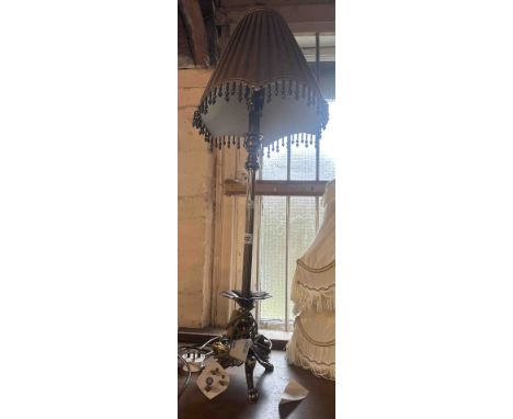 A decorative brass effect table lamp set on tripod base - sold with a beaded fabric shade