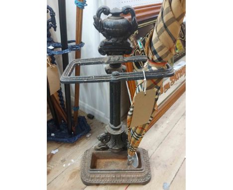 A late Victorian cast iron umbrella/stick stand with urn form pediment and drip tray to base