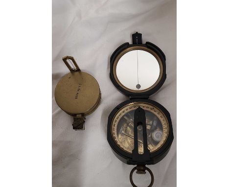 A modern military style compass with black japanned finish - sold with a smaller brass similar