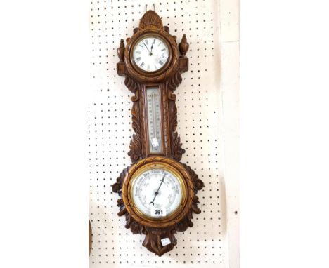 A late Victorian ornate polished oak cased aneroid wall barometer/thermometer and timepiece with platform escapement movement