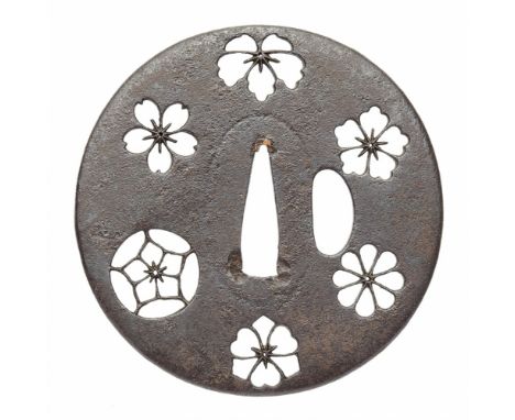  Tsuba. Eisen. 17./18. Jh.  Rund. In negativem Schattenriss sechs Blüten-mon, darunter kiri, sakura, und kiku.D 7,8 cmProven