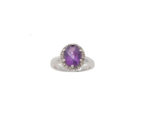 A diamond and amethyst ring, composed of an oval-cut amethyst to a surround of round brilliant-cut diamonds within a white me