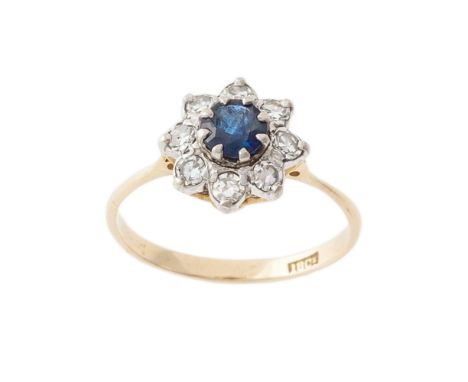 A sapphire and diamond ring, composed of a circular-cut sapphire to a surround of single-cut diamonds within an 18 carat gold