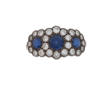 A diamond and sapphire ring, composed of a trio of circular-cut sapphires larger to centre to a surround of round brilliant-c