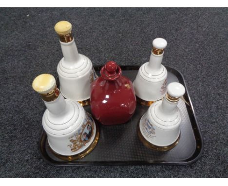 A tray of four Bells Scotch whisky decanters (one with contents unsealed) and one further decanter 