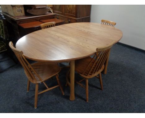 An Ercol elm extending kitchen table and set of four rail backed chairs 