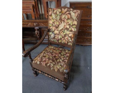 A carved oak scroll arm armchair in tapestry fabric 