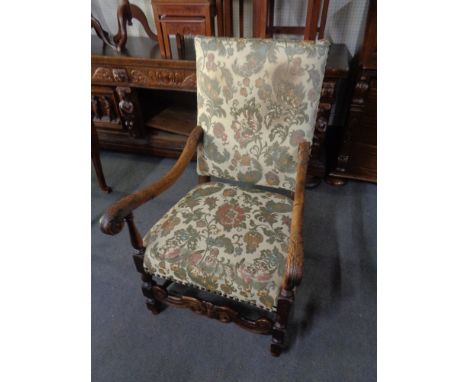 A carved oak scroll arm armchair in tapestry fabric 