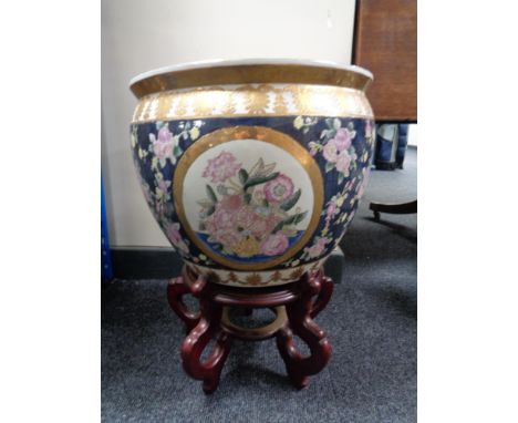 A fish bowl planter on wooden stand 