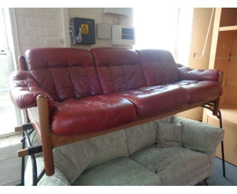 A late 20th century wooden framed three seater settee in red button leather 