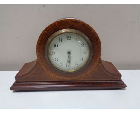 An antique French inlaid mahogany mantel clock on raised brass feet, with key. 