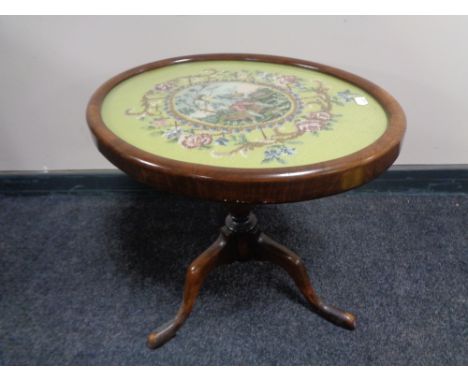 An antique mahogany pedestal wine table with tapestry panel top 