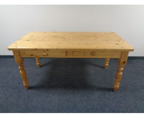 A pine farmhouse kitchen table together with a set of six rush seated ladder backed chairs 