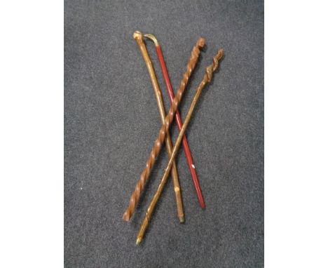 A bundle of four walking sticks including a brass cobra headed stick. 