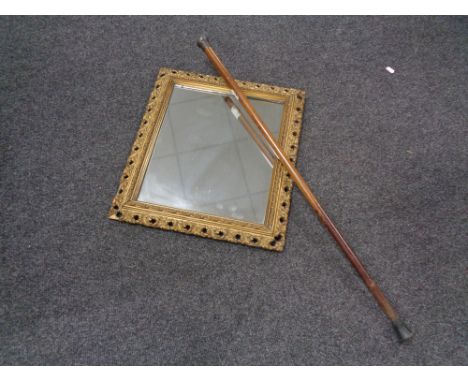 An antique gilt framed composition mirror together with a silver topped walking stick 