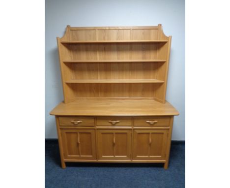 An Ercol elm dresser with cupboards and drawers beneath 