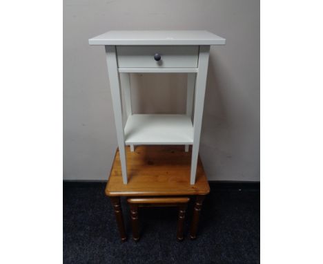 A pine lamp table fitted with a drawer together with a nest of two pine tables 