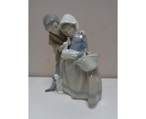 A Nao figure group, boy and girl with duck. 