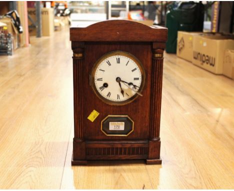 Wooden mantel clock, 34 cm high, with key, the brass workings marked with crossed arrows
