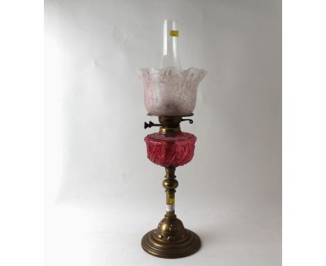 Brass column oil lamp with cranberry reservoir and etched glass shade, 65 cm high