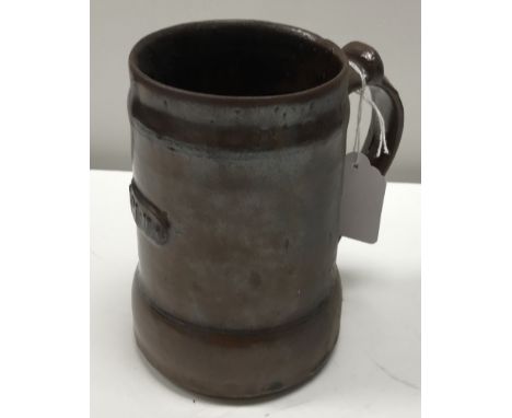 A Michael Cardew Abuja Pottery mug by Ladi Kwali, bearing plaque to front "Abuja" and two impressed marks to base of handle, 