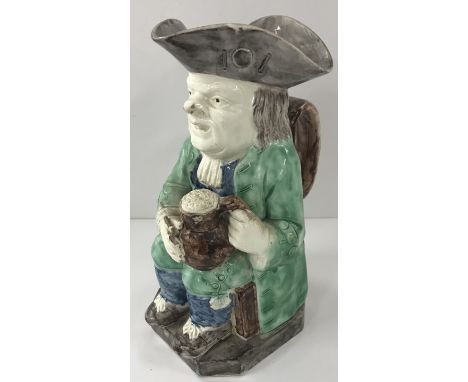 A late 18th Century Ralph Wood type cream ware Toby jug as a seated Toby with jug of beer and pipe, 25 cm high CONDITION REPO