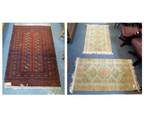 A pair of Persian design rugs in Messina green, approximately 68cm x 120cm, together with another rug with brown background, 