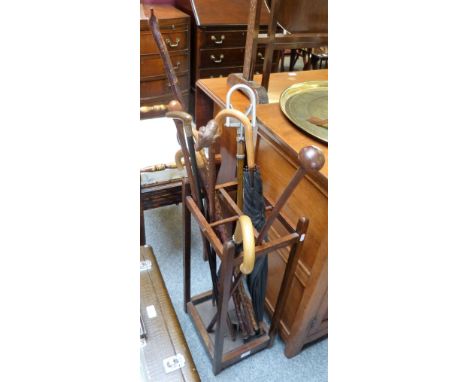 An oak open stick stand containing ten walking sticks/canes, umbrellas, shooting stick, etc. 