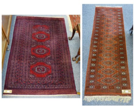 A geometric pattern rug with dark red background, 190cm x 122cm, together with a runner, 200cm x 66cm, brown background (2)