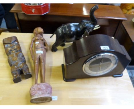 A bakelite cased mantel clock with 8-day chiming movement, a tribal carved hardwood figure, a modern Maori carved hardwood fi