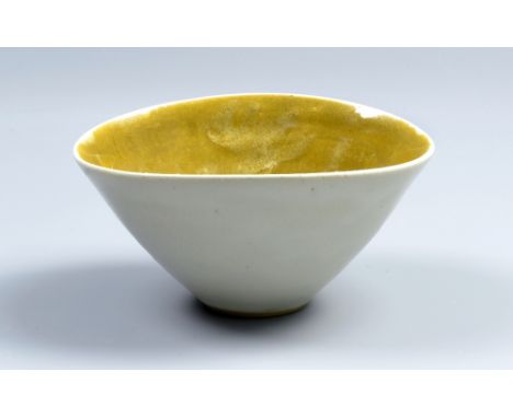 LUCIE RIE (1902-1995); an oval stoneware bowl, pitted white glaze to exterior, mustard yellow glaze to interior, impressed LR