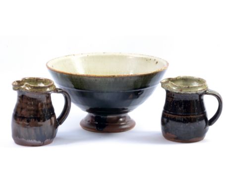 RICHARD BATTERHAM (born 1936); a pedestal bowl and two small jugs, green ash and tenmoku glaze, bowl diameter 23cm (3). (D)  
