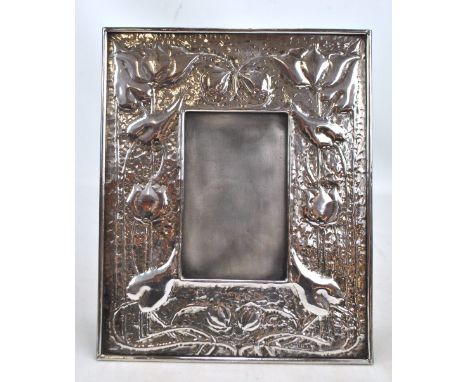 An early 20th century silver plated Arts and Crafts rectangular photo frame embossed with stylised water lily motifs on hamme