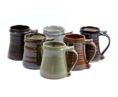 Leach Pottery; six stoneware tankards, impressed pottery marks, tallest height 13cm (6). CONDITION REPORT: Rim chips to one, 